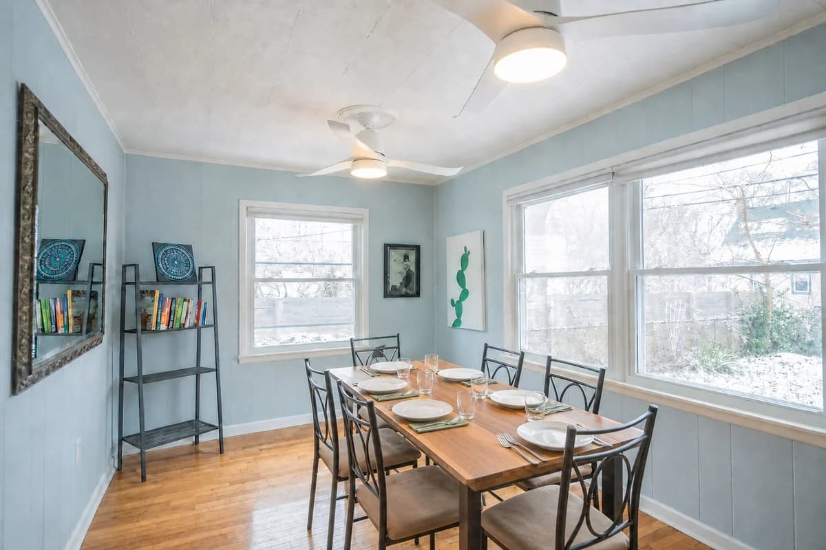 Sunlit dining room with a wooden table and blue walls