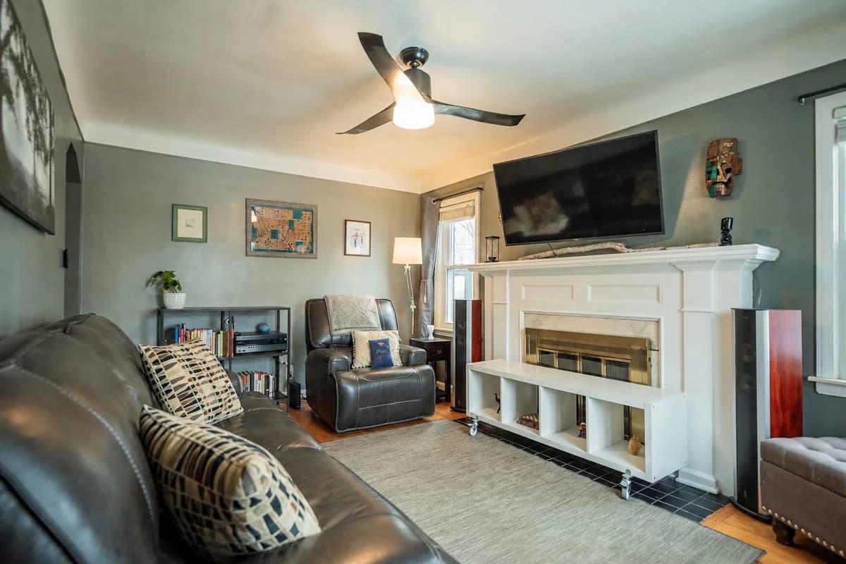 Living room with reclining leather seating, artwork and a fireplace